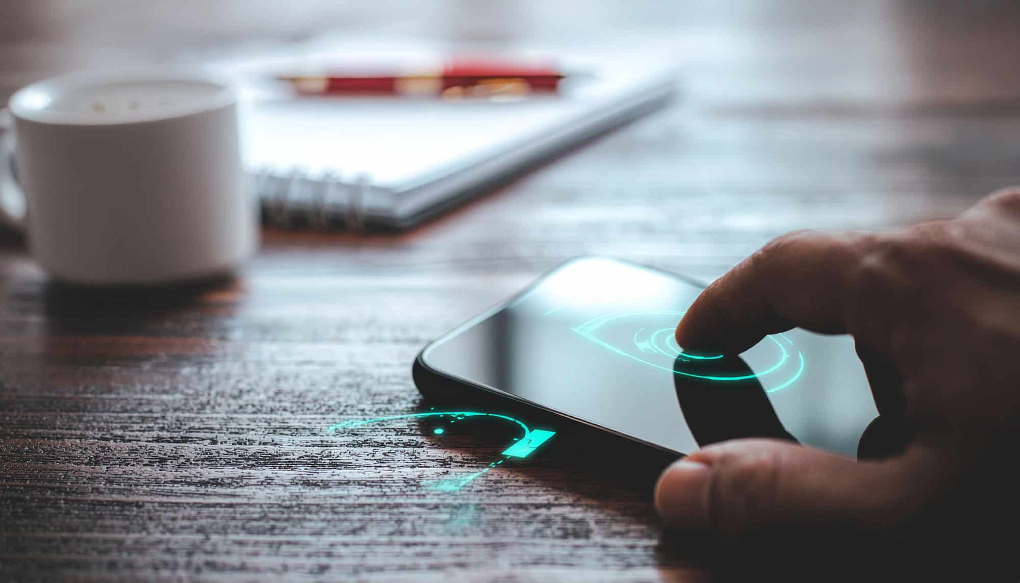 Person arbetar på laptop och mobil enhet med fokus på säkerhet och skydd av företagsdata i en modern IT-miljö